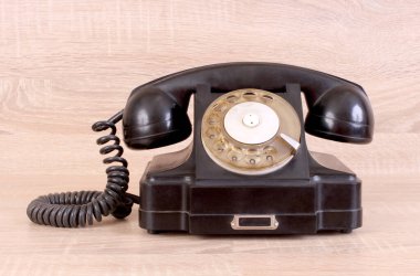 Kaliteli siyah telefon ahşap bir masada duruyor.