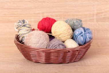 Ahşap bir masada çok renkli yün toplar.