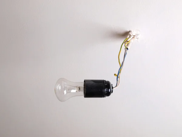 Lâmpada elétrica em um teto branco — Fotografia de Stock