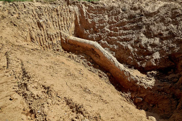 One old water pipe was discovered during the reconstruction of the water supply system in the ground — Stock Photo, Image