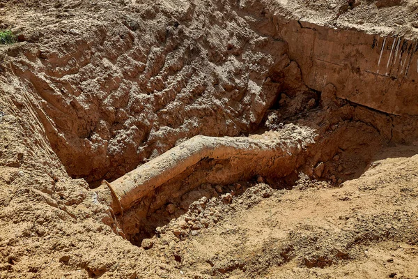 An old water pipe was found in the trench during excavations in connection with the reconstruction of the water supply network — Stock Photo, Image