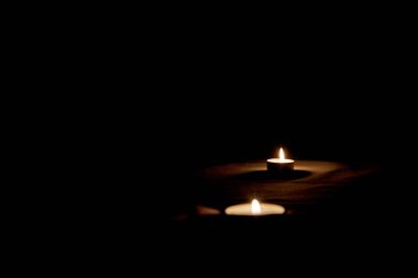 Karanlıktaki anma anısına masada bir mum yanıyor.