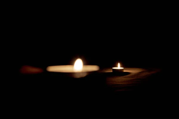 ろうそくは暗闇の中で記念を記念してテーブルの上で焼かれます — ストック写真