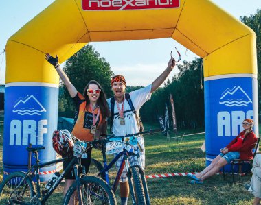 26-27 Mayıs 2018, Naliboki, Belarus Bir çift bisikletçi şişme kemer yakınlarındaki bitiş çizgisini kutluyor