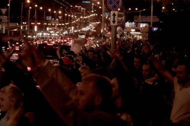 14 Ağustos 2020 'de, Minsk Belarus' ta gece, şehirde protestolar oluyor, yoldan geçen birçok mutlu insan onlara korna çalan arabaların yanında duruyor.