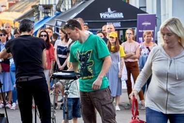 1 Haziran 2019 Minsk Belarus. İki müzisyen sokaktaki konserden önce müzik enstrümanlarını akort ediyor.