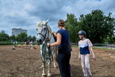 21 Haziran 2020 Minsk Belarus eğitmeni kızlar mutlu bir kıza ata nasıl binileceğini gösterir.