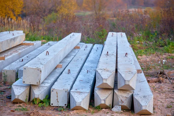 Reinforced concrete piles for building houses lie on the ground