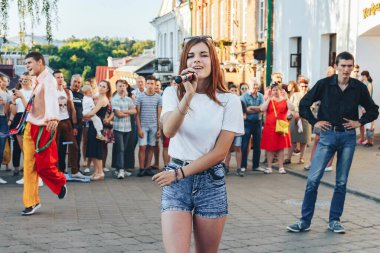 4 Ağustos 2018, Minsk Belarus. Akşam vakti, elinde mikrofonla şarkı söyleyen güzel bir kızın portresini kapat.