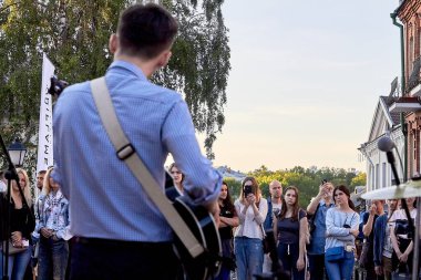 1 Haziran 2019 Minsk Belarus. Sokakta gitar çalan bir müzisyeni izleyen bir kalabalık.