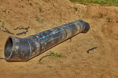 Su şebekesinin kurulumu. Plastik su borusu, yerdeki tesisin yönüne doğru uzanıyor..