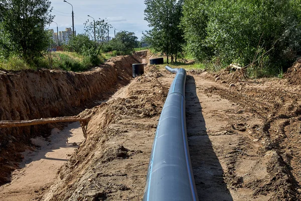 Plastic water pipe lies next to the trench for installation.Civil engineering — Stock Photo, Image