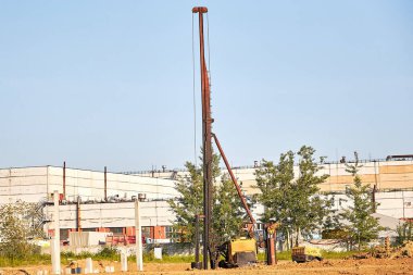 İnşaat alanında beton yığınları taşımak için matkap ya da makine