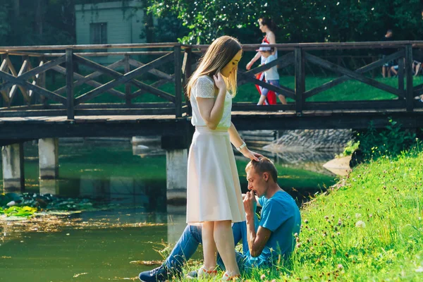 A couple in love walks in a summer park by the lake