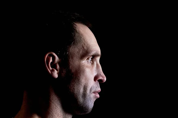 Brutal mature man in profile on dark background