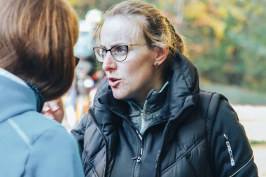 14 Ekim 2018, Minsk, Belarus.2018 Olimpik Kros Kupası XCO Medvezhino 'da. Park' ta konuşan gözlüklü bir kadının yakın çekimi.