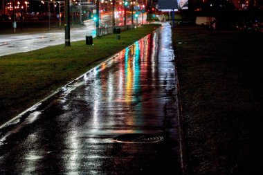 Yağmurlu bir geceden sonra yansıyan ışıklarla dolu bir gece şehri