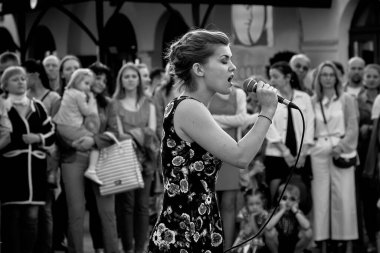 May 25, 2019 Minsk Belarus A street concert in which a close-up of a beautiful woman with a microphone sings on the street in front of the audience