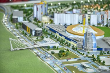 Gökdelenleri olan küçük bir kasabanın mimarisi, arabalı bir yol, yol boyunca bir köprü.