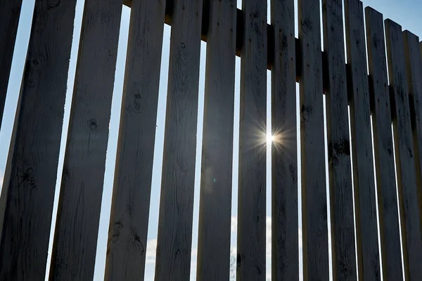 晴れた夏の日に木製の柵のクローズアップ 太陽がフェンスを通って輝いている — ストック写真