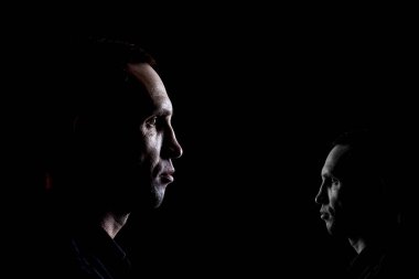 İki tip insan portresi, karanlık bir arkaplanda psikolojik bir fotoğraf. Büyük ve küçük bir erkek resmi.