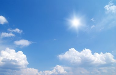 Güneş mavi gökyüzünde bulutlarla, hava durumuyla 