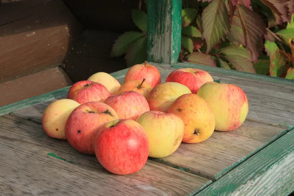Äpplen på träbänk — Stockfoto