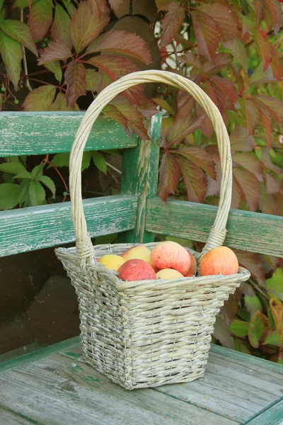 Ripe apple in braided basket — Stock Photo, Image