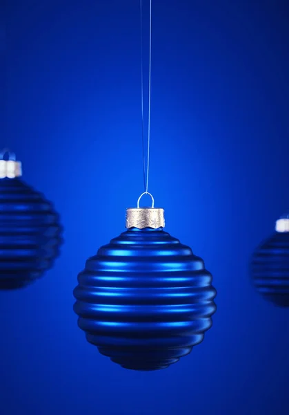 Drei Horizontal Gerippte Königsblaue Weihnachtskugeln Hängen Schnüren Vor Blauem Hintergrund — Stockfoto