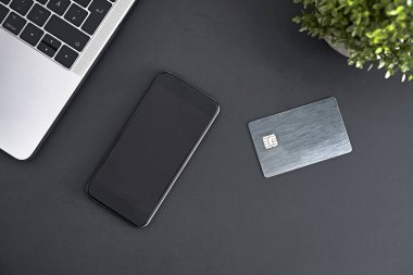 Laptop, akıllı telefon ve elektronik çip kartı Matt Grey 'in masasında duruyordu. İnternetten ödüyorum. Modern teknoloji, kablosuz aygıt ve enerji aktarımı.