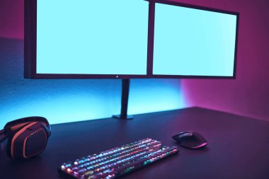 İki yüksek çözünürlüklü ekran, renkli ışıklandırma ve oyun fareli klavye. İçeriğinizi eklemek için boş monitör. Profesyonel bilgisayar oyunu, esport işi ve online dünya konsepti.