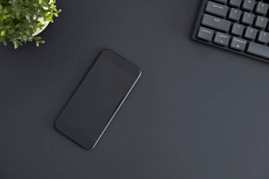 Masasında siyah beyaz ekran olan cep telefonunun en alt görüntüsü. Modern teknoloji, kablosuz aygıt ve enerji aktarımı.
