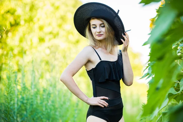 Blond Europeisk Flicka Svart Baddräkt Och Hatt Naturen Med Solrosor — Stockfoto