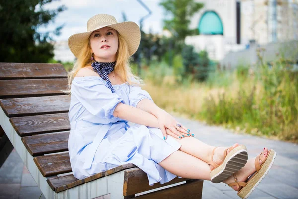 Blondýny Modrých Šatech Krásný Klobouk Pózující Lavičce Městském Parku — Stock fotografie