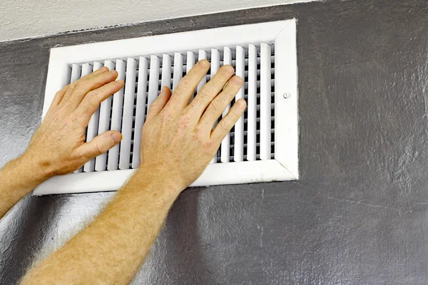 Twee handen in de voorkant van een Air Vent — Stockfoto