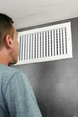 Man Looking Into Air Duct clipart