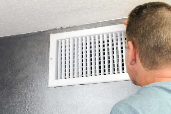 Homem olhando em uma ventilação de ar — Fotografia de Stock