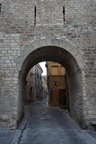 Puerta de arco y casas de piedra en Aniane — Foto de Stock