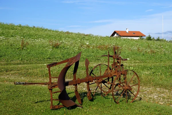 Rusty plough on the green grass — Stock Photo, Image