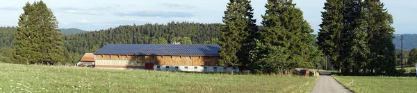 Langer Stall mit Solarzelle auf dem Dach — Stockfoto