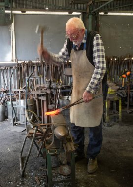 PERTH, AUSTRALYA - 28 AĞUSTUSTOS 2021: Batı Avustralya 'da, Perth' teki örsünde çalışan kimliği belirsiz bir demirci.