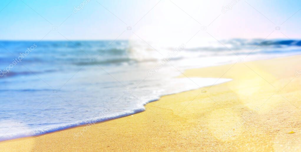 abstract summer vacation background of blurred beach sand and sea wave