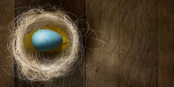 Arte Huevos de Pascua en nido sobre mesa de madera rústica —  Fotos de Stock