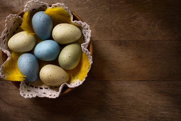 Ovos de Páscoa em ninho em mesa de madeira rústica — Fotografia de Stock