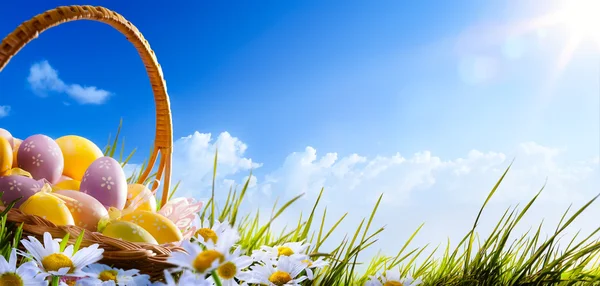 Coloridos huevos de Pascua decorados con flores en la hierba en azul — Foto de Stock