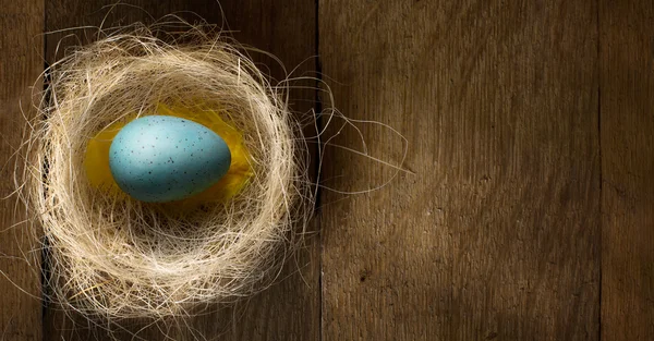 Arte Huevos de Pascua en nido sobre mesa de madera rústica —  Fotos de Stock