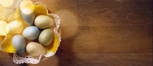 Huevos de Pascua en nido sobre mesa rústica de madera —  Fotos de Stock