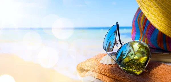 Sombrero de paja, bolso y gafas de sol en una playa tropical —  Fotos de Stock