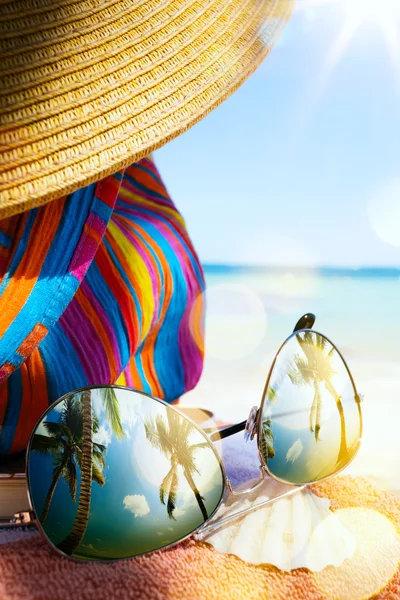 Arte Sombrero de paja, bolso y gafas de sol en una playa tropical —  Fotos de Stock