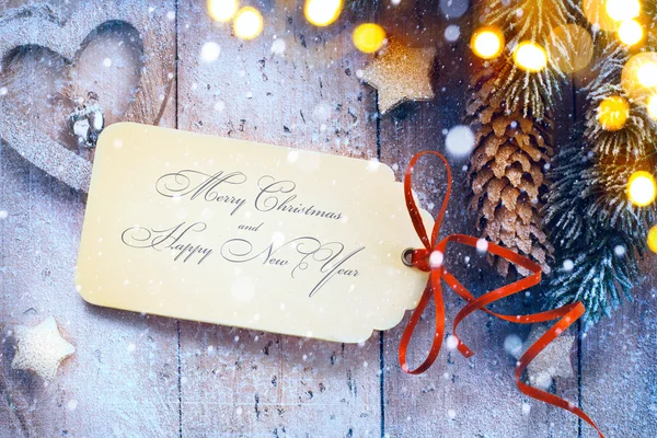 Fond de Noël avec lumière d'arbre et carte de papier de Noël — Photo